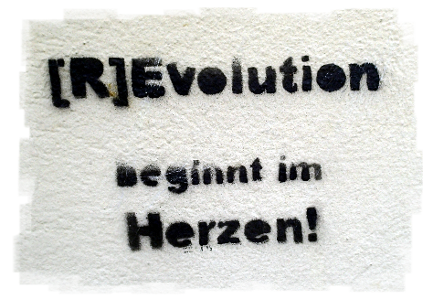 Auf eine Wand gesprayt steht der Schriftzug "[R]Evolution beginnt im Herzen!" geschrieben.